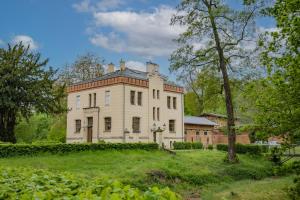 an old house on top of a grassy hill at Hotel Jagdschloss Letzlingen in Letzlingen