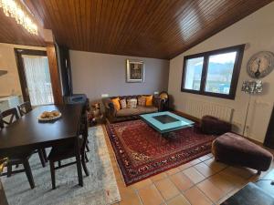 ein Wohnzimmer mit einem Tisch und einem Sofa in der Unterkunft Can Rossa in Palol de Oñar