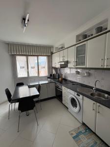 a kitchen with white cabinets and a table and chairs at El paraíso I in Raxó