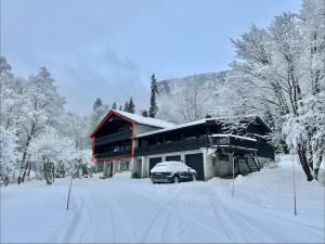 a house with a car parked in the snow at Spacious Hemsedal villa with mountain views in Hemsedal