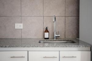 a kitchen sink with a bottle of wine on it at Temporario Sur, Depto ideal familias con cuna Pet-friendly, zona IUPA in General Roca