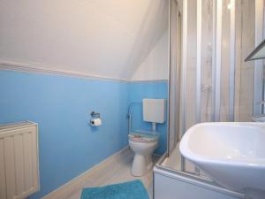 a blue bathroom with a sink and a toilet at Ferienwohnung Familie Schmidt in Bergen auf Rügen