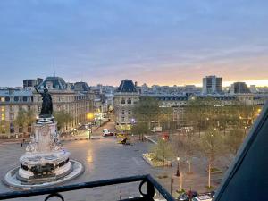 a view of a city with a statue in a plaza at Eiffel Tower View Apartment in Paris