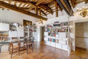 a dining room with a table and chairs and bookshelves at Villa Colloredo in Dolo