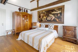 a bedroom with a bed and a painting on the wall at Villa Colloredo in Dolo