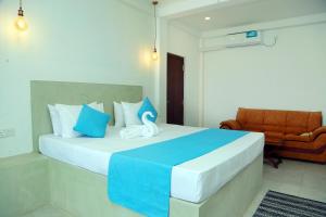 a bedroom with a large bed with blue and white pillows at Cozy Cocos Midigama in Ahangama +172 photos