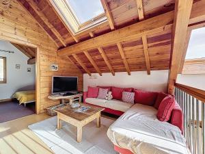 a living room with a red couch and a tv at Chalet Face aux Etoiles in Molines-en-Queyras