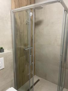 a shower with a glass door in a bathroom at Orhideja 075 in Tuzla +13 photos