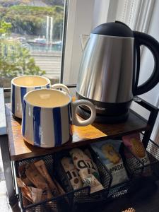 a shelf with two cups and a coffee pot on it at Nook and Scranny in Tarbert