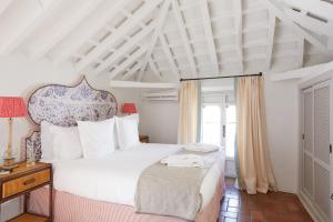 a bedroom with a large white bed and a window at Posada La Sacristía Tarifa in Tarifa