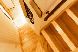 a room with wooden floors and a door with a window at Nesoberi VILLA TAKASU in Kanoya