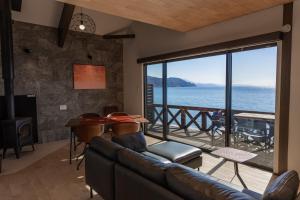 a living room with a couch and a view of the ocean at Nesoberi VILLA TAKASU in Kanoya