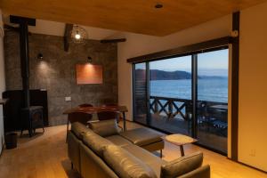 a living room with a couch and a view of the ocean at Nesoberi VILLA TAKASU in Kanoya