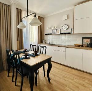 a kitchen with a table and chairs in a room at Apartament 101 in Piła