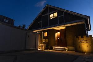 a black house with a garage at night at Nesoberi VILLA TAKASU in Kanoya +5 photos