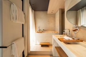 a bathroom with a sink and a tub and a mirror at Hotel de Nell in Paris