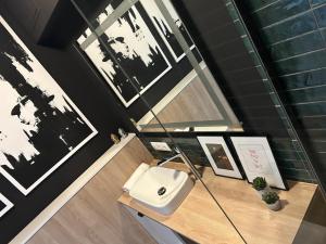 a bathroom with a sink on a desk with pictures at Apartament 101 in Piła