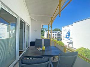 a porch with a table and chairs on a balcony at Villa Störtebeker - Whg 05 in Baabe