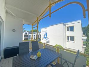 a deck with a table and chairs on a balcony at Villa Störtebeker - Whg 05 in Baabe +22 photos