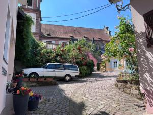 a white car parked in a street with flowers at Ferienwohnung Furtwängler in Ettenheim