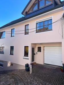 a white house with a garage at Ferienwohnung Furtwängler in Ettenheim