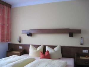 a bedroom with a bed with two red pillows at Bauernhof Huber in Wenns