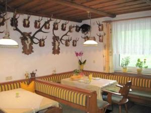 a dining room with a table and some antlers on the wall at Bauernhof Huber in Wenns +5 photos