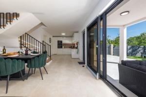 a kitchen and living room with a table and chairs at Villa Flora Zadar Villas in Perušić Benkovački +25 photos
