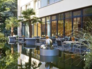 a restaurant with tables and chairs in front of a building at Mercure Hotel Plaza Essen in Essen