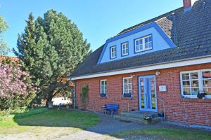 a red brick house with a blue door at Ferienwohnung an den Vilmnitzer Wi in Vilmnitz