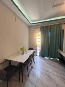 a dining room with a white table and chairs at Résidence meublée du boss in Abidjan