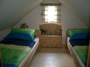 a attic bedroom with two beds and a window at Kellerstöckl Leitner in Strem +38 photos