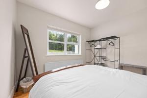 a white bedroom with a bed and a window at Hilltop Views by Escape Ordinary in Killyhevlin