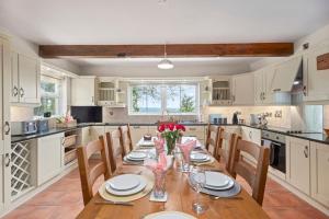 a large kitchen with a wooden table and chairs at Hilltop Views by Escape Ordinary in Killyhevlin
