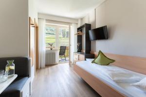 a hotel room with a bed and a television at Feldhof Schenna in Schenna