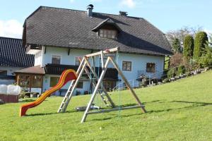 Ein Spielplatz mit Rutsche vor einem Haus. in der Unterkunft Minabauer in Altmünster