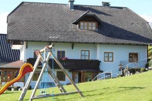 ein Haus mit einem Spielplatz davor in der Unterkunft Minabauer in Altmünster