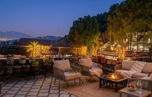 a patio with couches and chairs on a roof at Ranim Family Lodge - Abbottabad in Abbottabad
