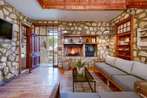 a living room with a stone wall with a fireplace at Arniston Hotel Manor House in Arniston