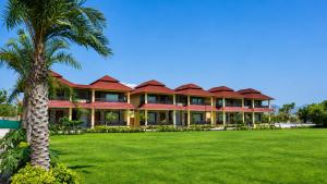 a large house with a palm tree in front of it at Vijay Vilas by Arow Hotels and Resorts in Pushkar