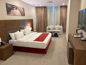 a hotel room with a large bed and a television at Garden Hotel in Kuwait