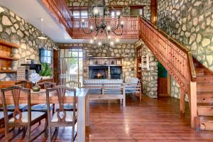 a living room with a staircase and a stone wall at Arniston Hotel Manor House in Arniston