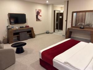 a hotel room with a bed and a television at Garden Hotel in Kuwait