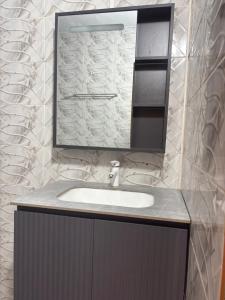 a bathroom with a sink and a mirror at Résidence meublée du boss in Abidjan