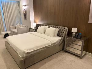 a bedroom with a large bed and a chair at Garden Hotel in Kuwait +69 photos