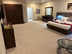 a large bedroom with a bed and a mirror at Garden Hotel in Kuwait