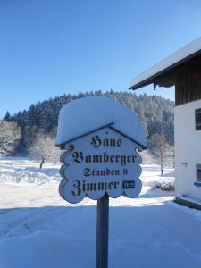 a snow covered sign in front of a building at Haus Bamberger in Fischbachau +4 photos