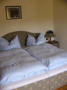 a bed with white sheets and pillows in a bedroom at Ferienwohnungen Hauerperle in Neudörfl