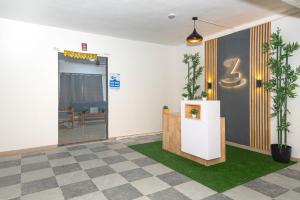an office lobby with a reception desk and plants at Z Express Zen Elite in Pune +12 photos