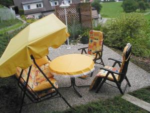 a table and two chairs with a yellow umbrella at Appartement Ferienwohnung Bilek in Gmunden